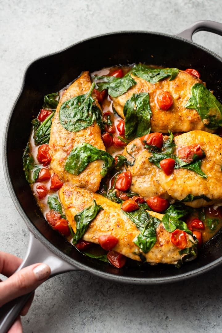 tomato spinach white wine chicken in a skillet