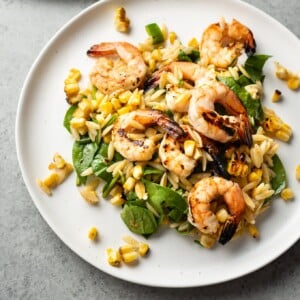 Cajun grilled shrimp and orzo salad on two white plates