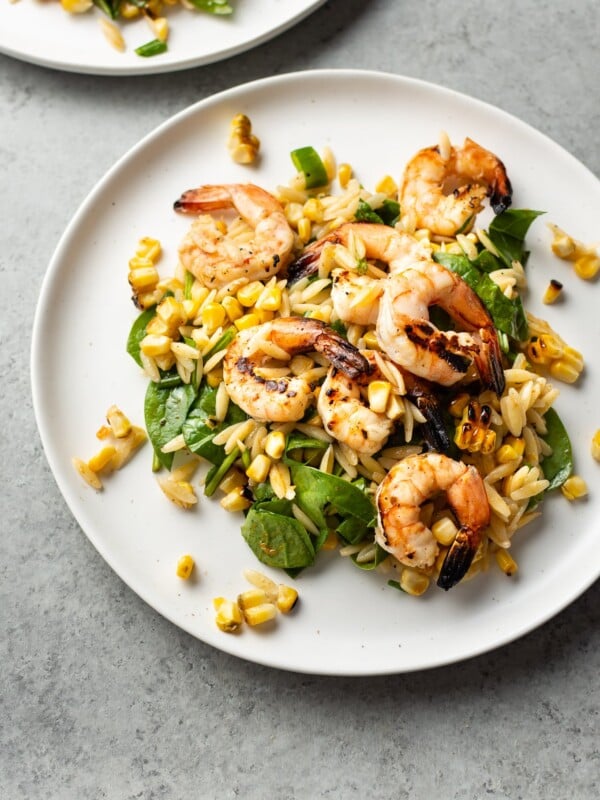 Cajun grilled shrimp and orzo salad on two white plates