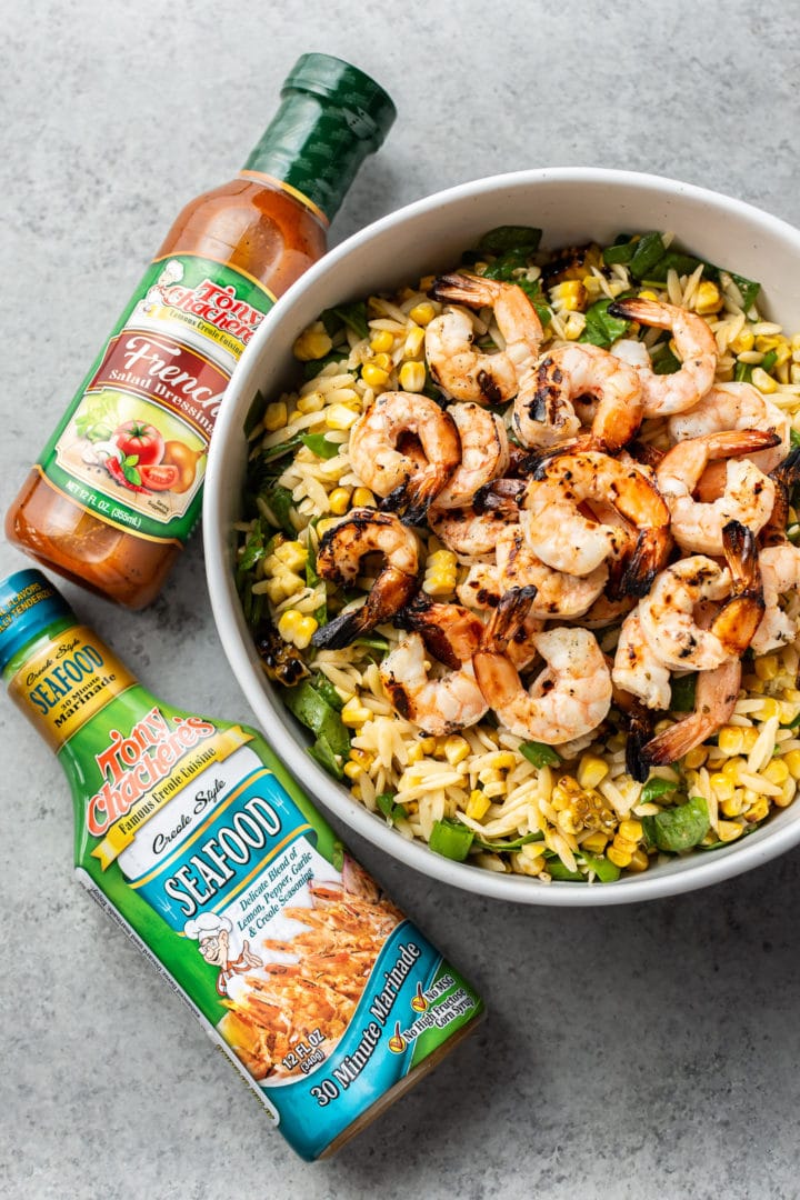 Cajun grilled shrimp orzo salad surrounded by Tony Chachere's Seafood Marinade and Tony's Chachere's French Dressing