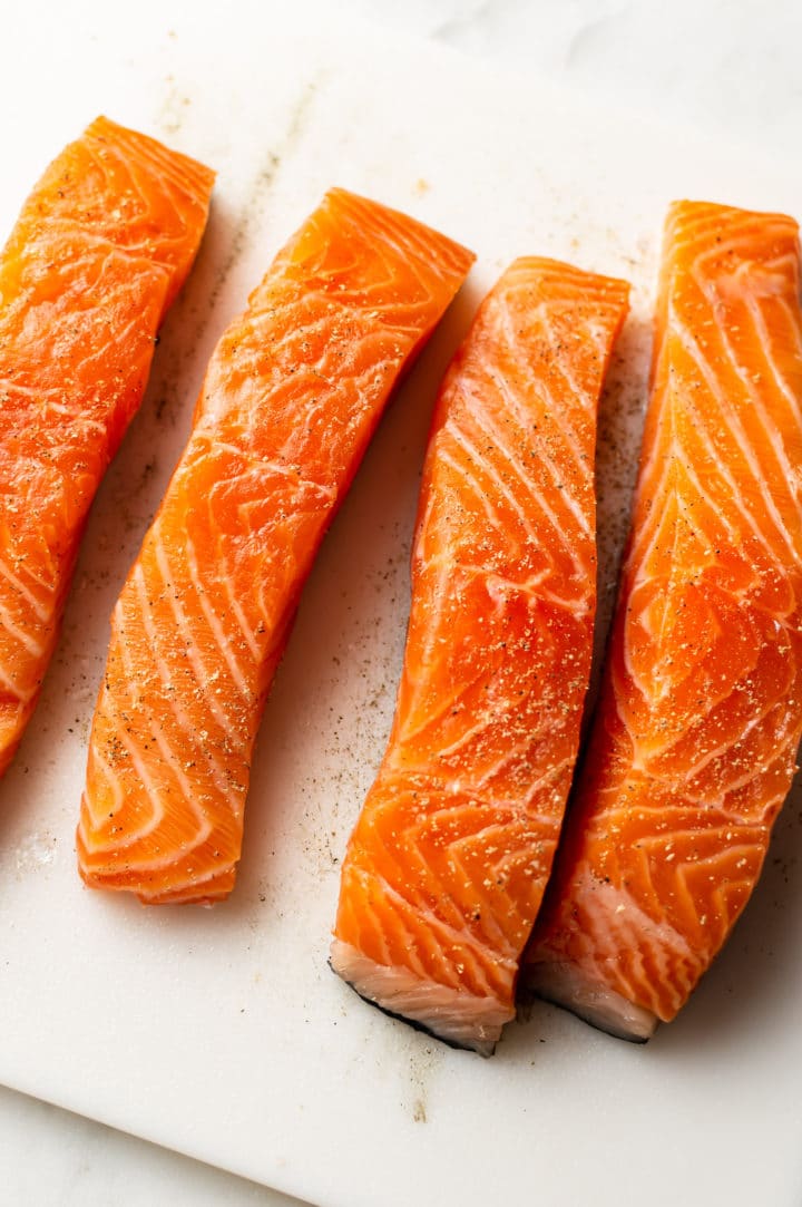 4 fresh salmon pieces on a cutting board