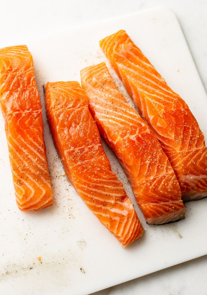 4 fresh salmon pieces on a cutting board