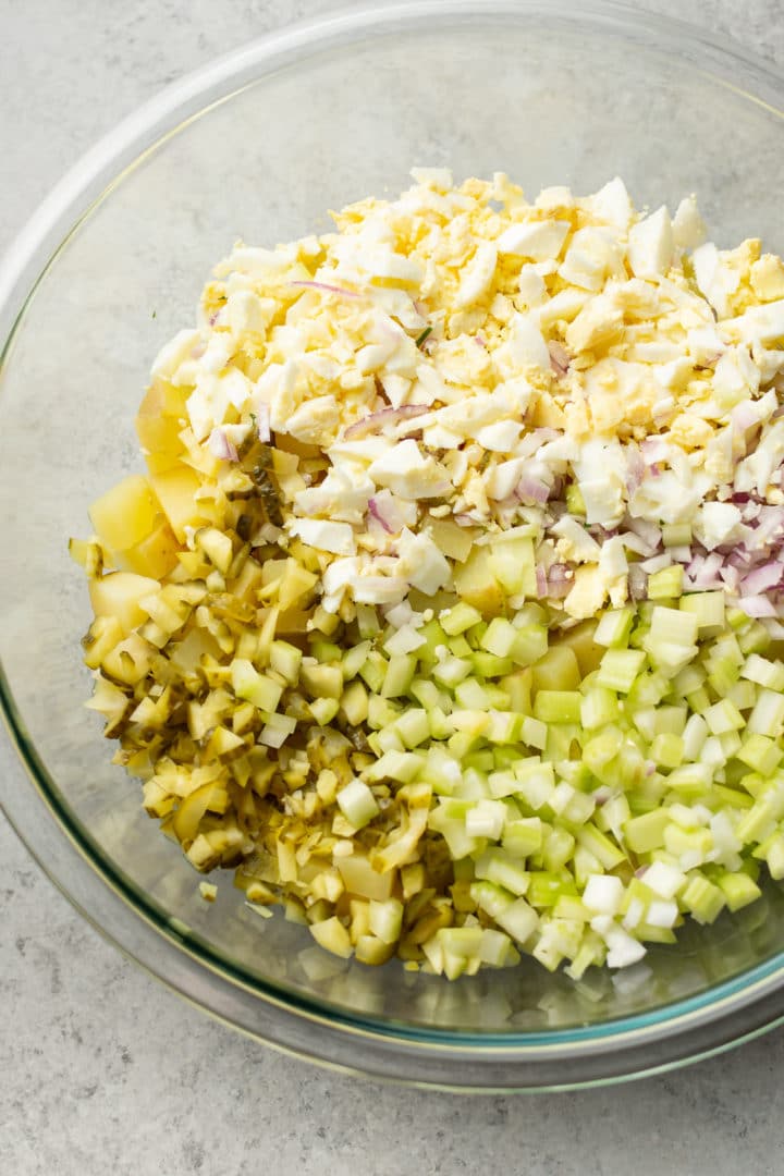 ingredients for classic potato salad with eggs in a glass prep bowl (dressing not added yet)