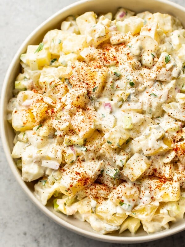 classic potato salad with egg in a beige serving bowl