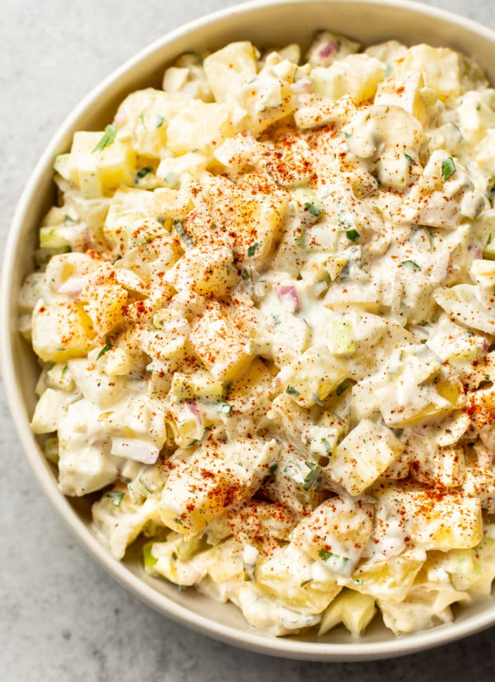 classic potato salad with egg in a beige serving bowl