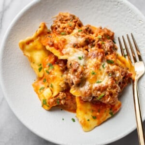 cheesy baked ravioli in a shallow bowl