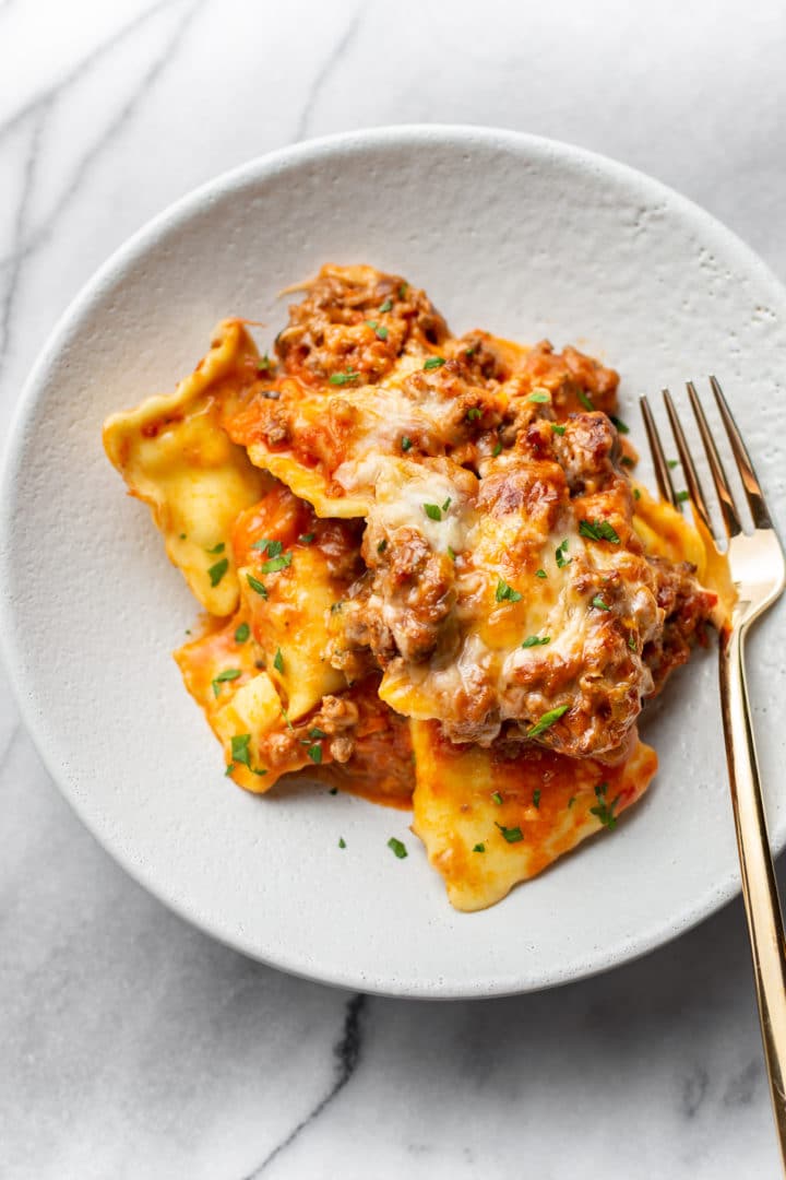 cheesy baked ravioli in a shallow bowl