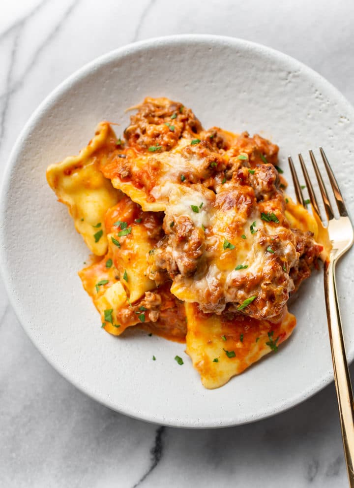 cheesy baked ravioli in a shallow bowl