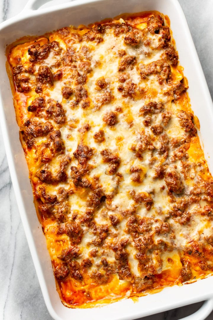 cheesy ravioli bake in a white baking dish