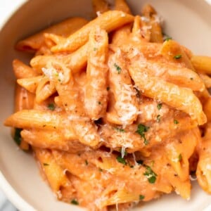 creamy tomato pasta in a white bowl