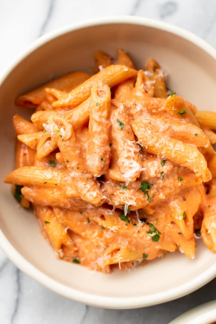 creamy tomato pasta in a white bowl