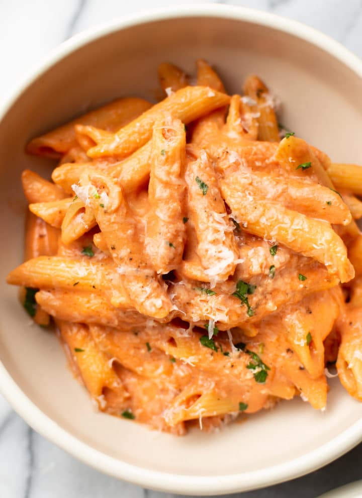 creamy tomato pasta in a white bowl