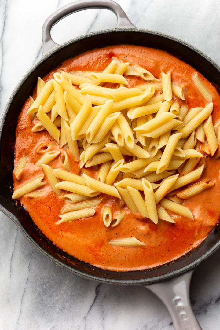 tomato cream sauce in a skillet ready to be tossed with penne