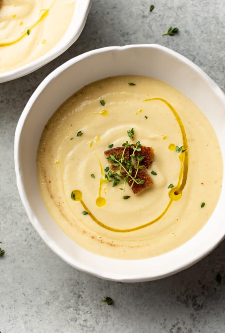 creamy cauliflower soup in two white bowls