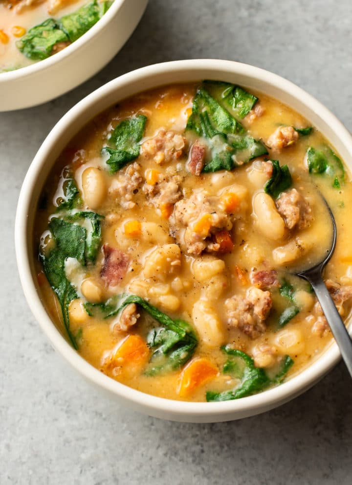 Italian sausage white bean soup (two bowls) with a spoon