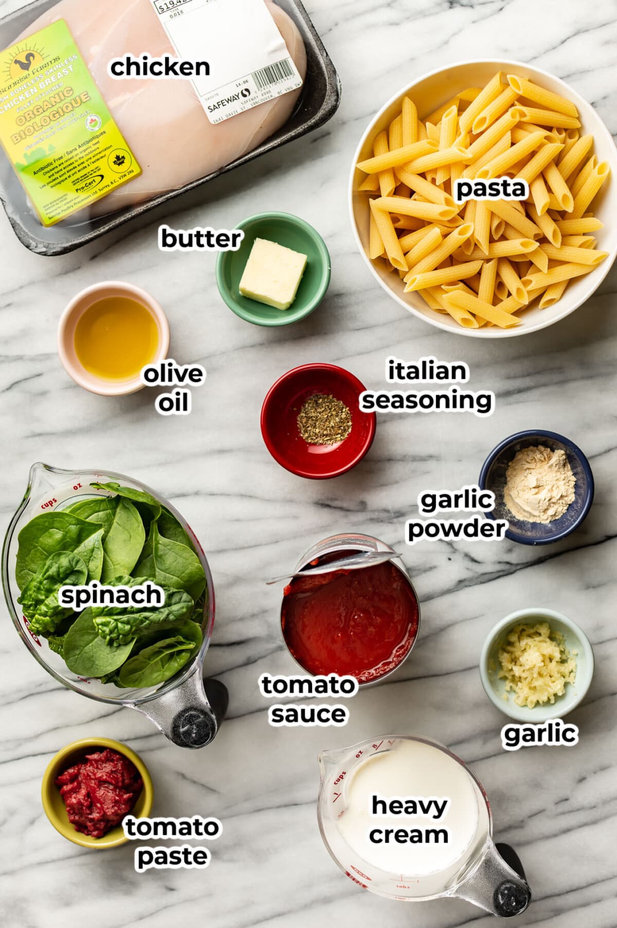 ingredients for tomato spinach chicken pasta in prep bowls and measuring cups