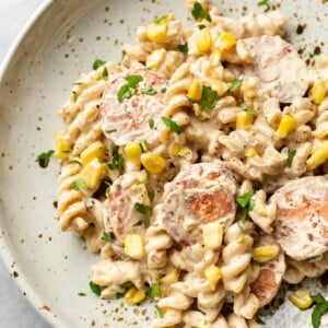 creamy smoked sausage pasta in a beige bowl