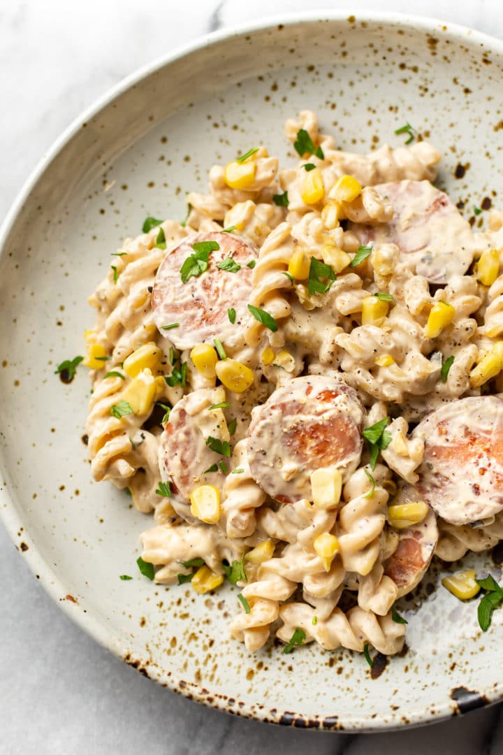 creamy smoked sausage pasta in a beige bowl