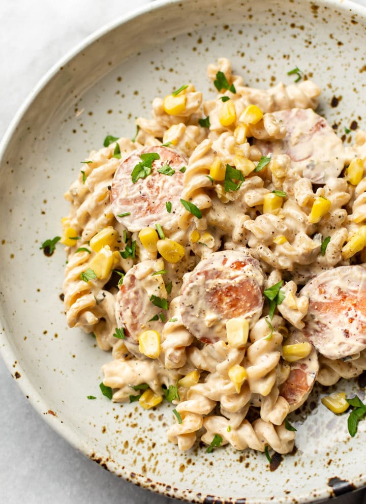 creamy smoked sausage pasta in a beige bowl