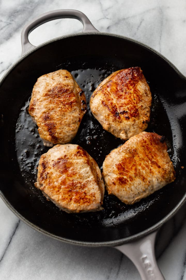 seared pork chops in a skillet