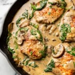 creamy spinach mushroom pork chops in a skillet