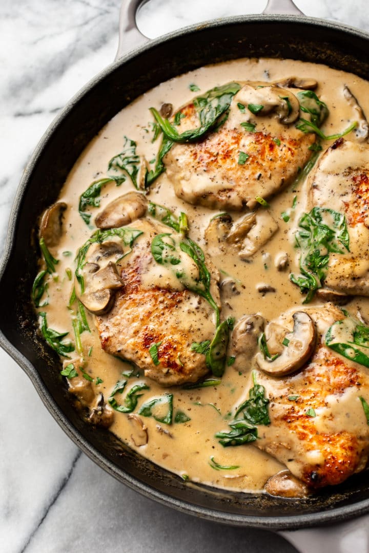 creamy spinach mushroom pork chops in a skillet