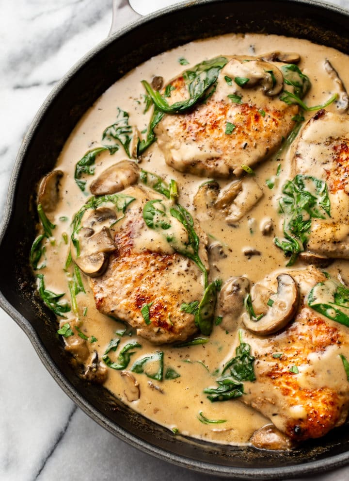 creamy spinach mushroom pork chops in a skillet