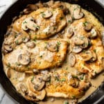 creamy white wine mushroom chicken in a skillet on a marble background