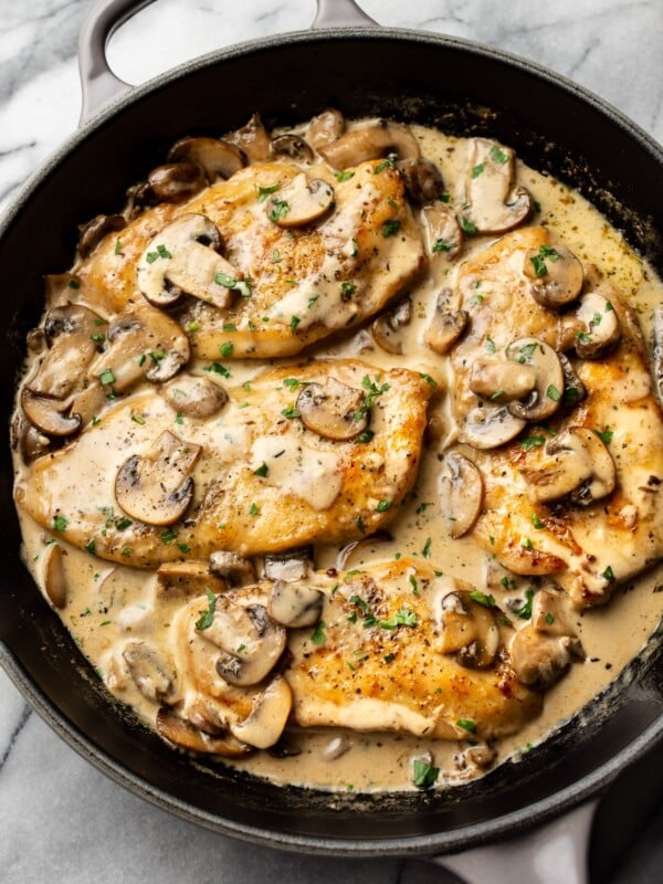 creamy white wine mushroom chicken in a skillet on a marble background