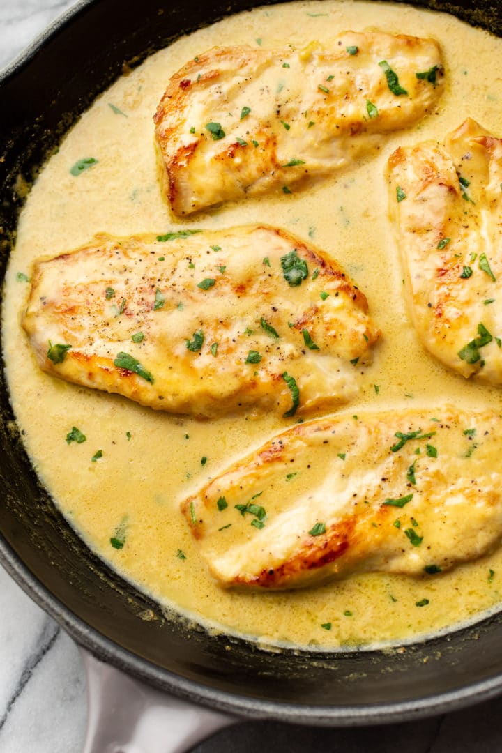close-up of creamy lemon pepper chicken breasts in a skillet