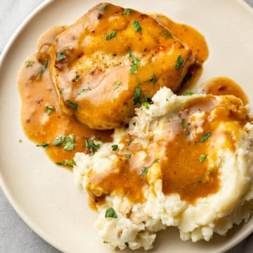 ranch pork chops on a plate with mashed potatoes and plenty of gravy