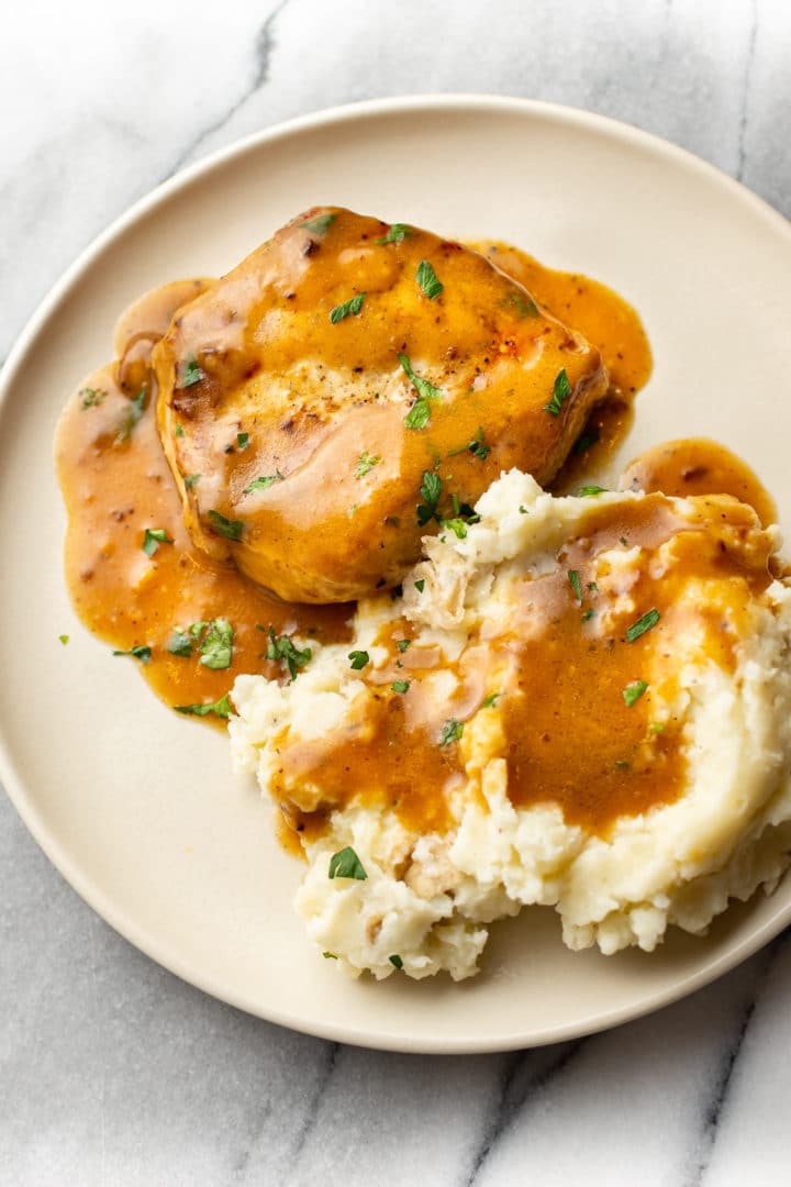 ranch pork chops on a plate with mashed potatoes and plenty of gravy