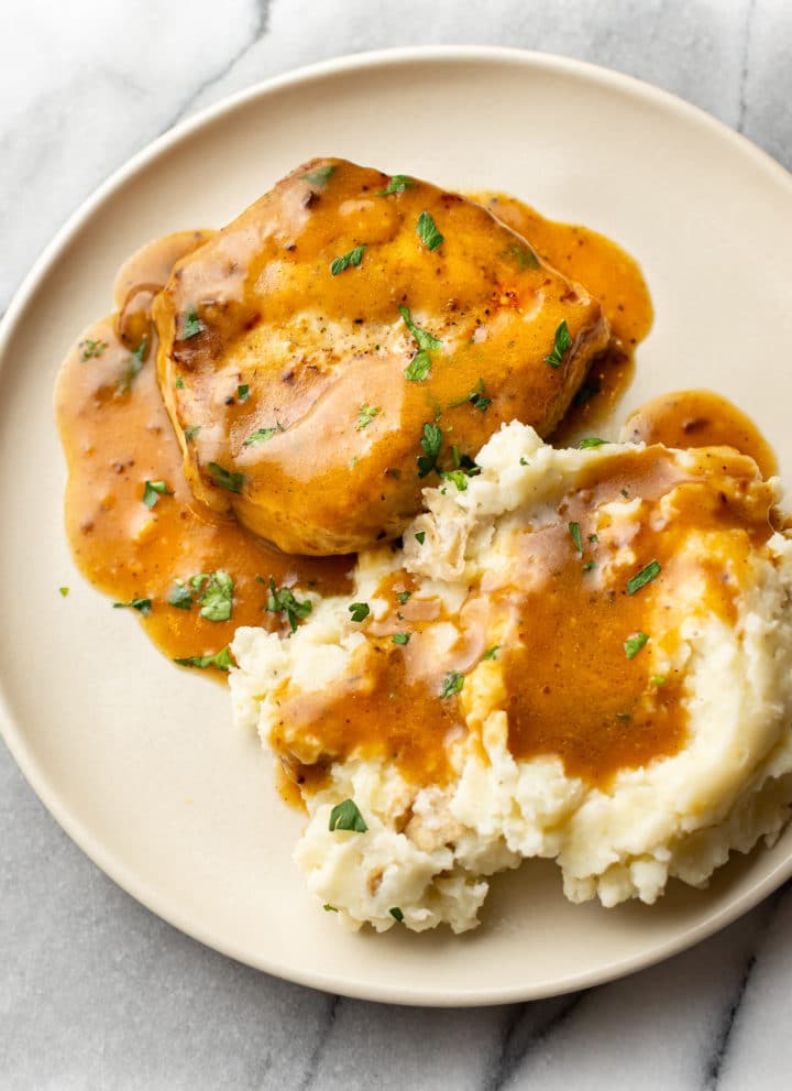 ranch pork chops on a plate with mashed potatoes and plenty of gravy