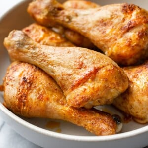 close-up of baked chicken legs (drumsticks) stacked in a bowl