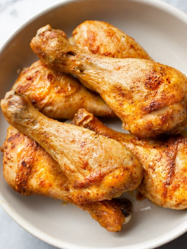 stacked baked drumsticks in a bowl