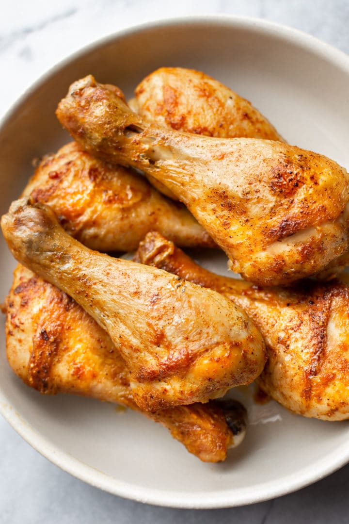stacked baked drumsticks in a bowl
