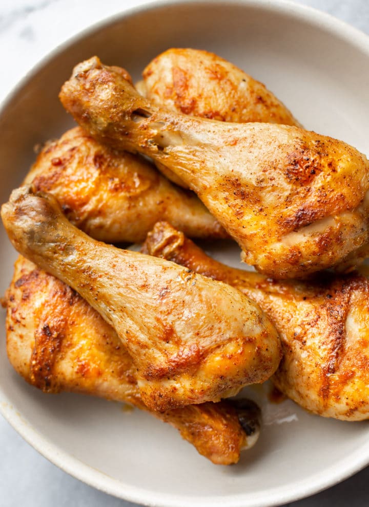 stacked baked drumsticks in a bowl