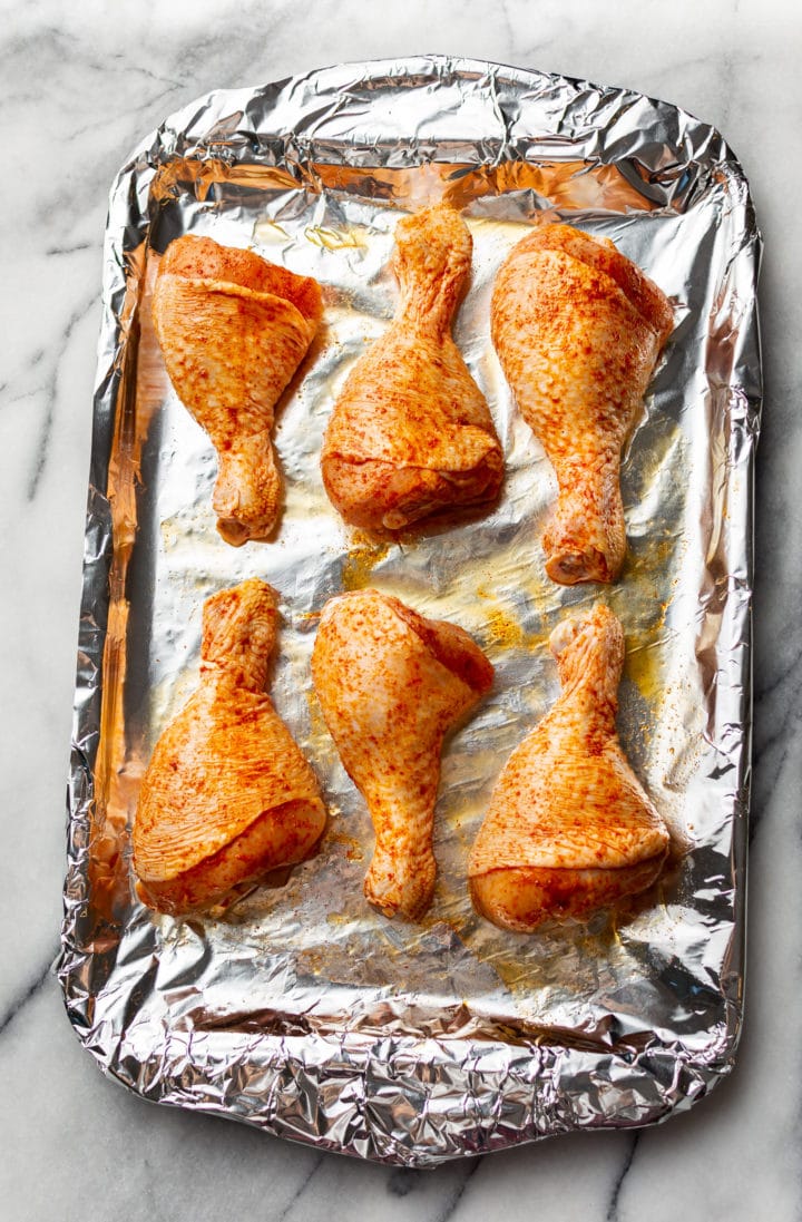 chicken legs on a baking sheet ready for the oven