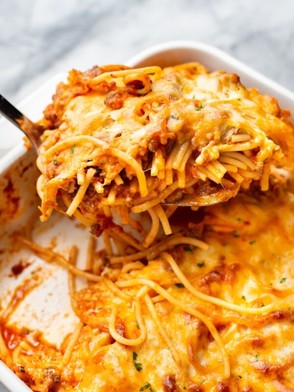 close-up of baked spaghetti in a casserole dish being lifted out with a spatula