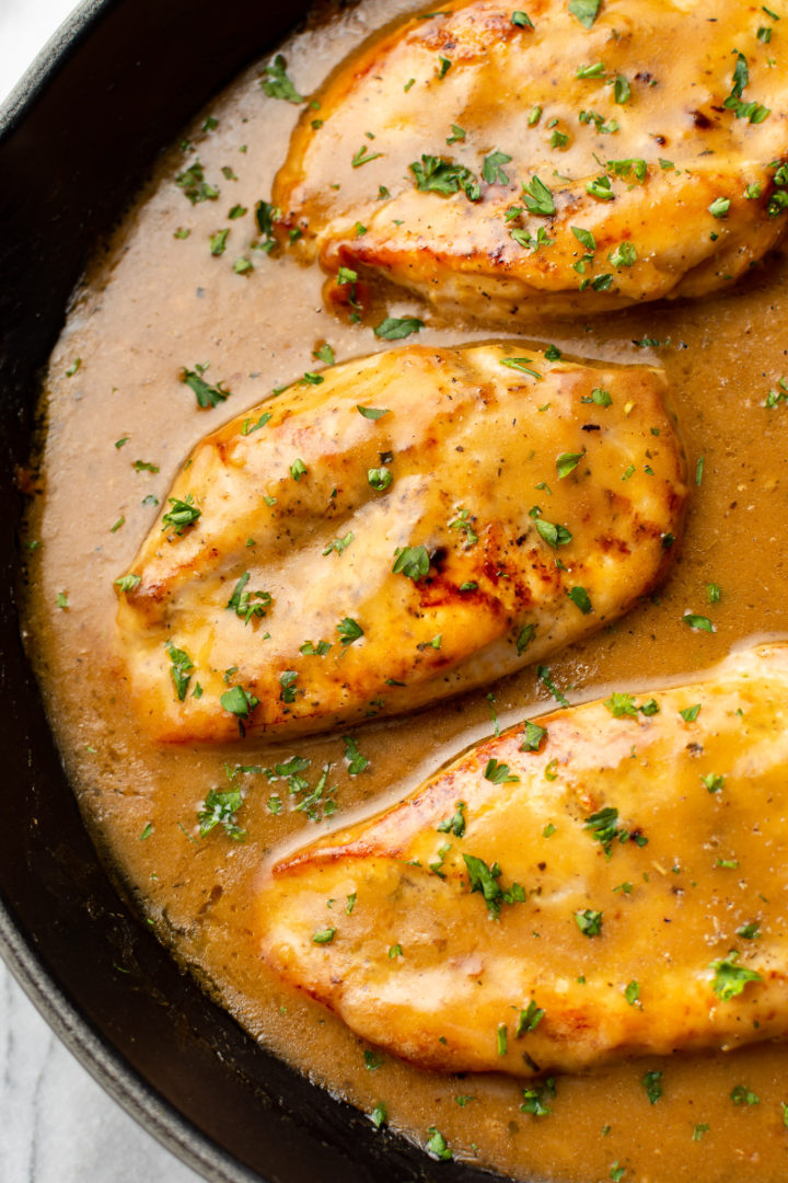 close-up of chicken breasts and gravy in a skillet