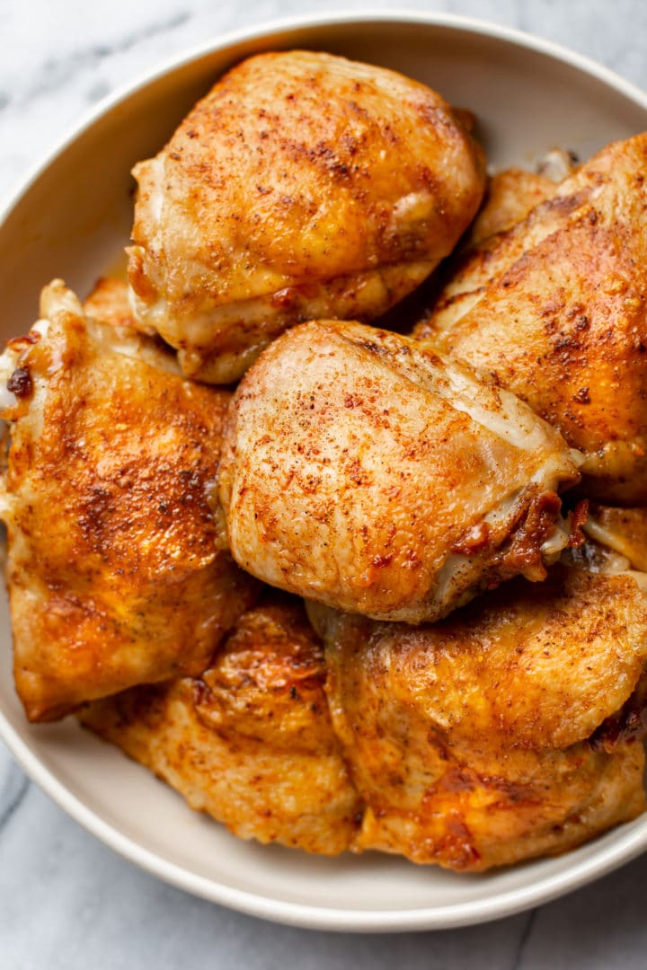 crispy baked chicken thighs stacked in a bowl