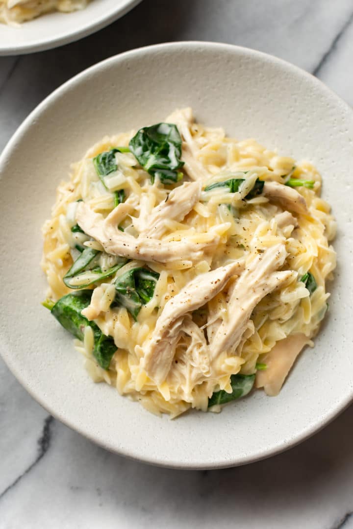 close-up of lemon chicken orzo in two white shallow bowls