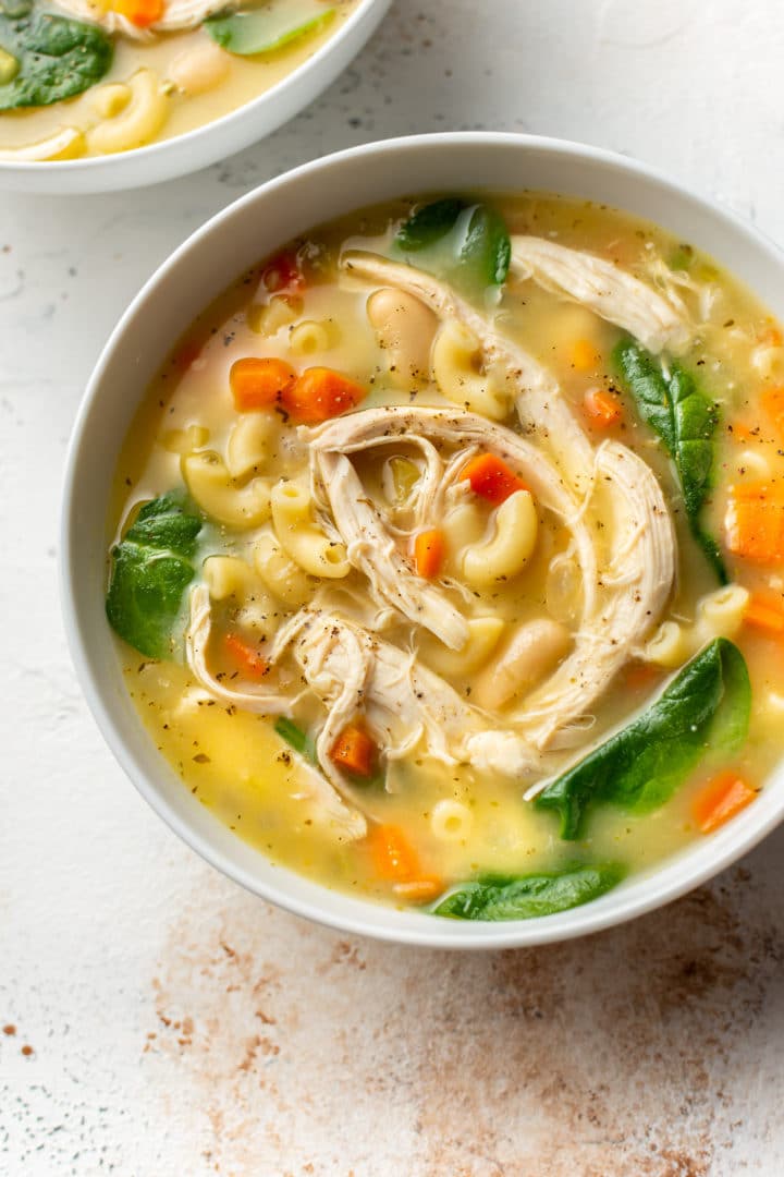 lemony white bean chicken soup in two white bowls