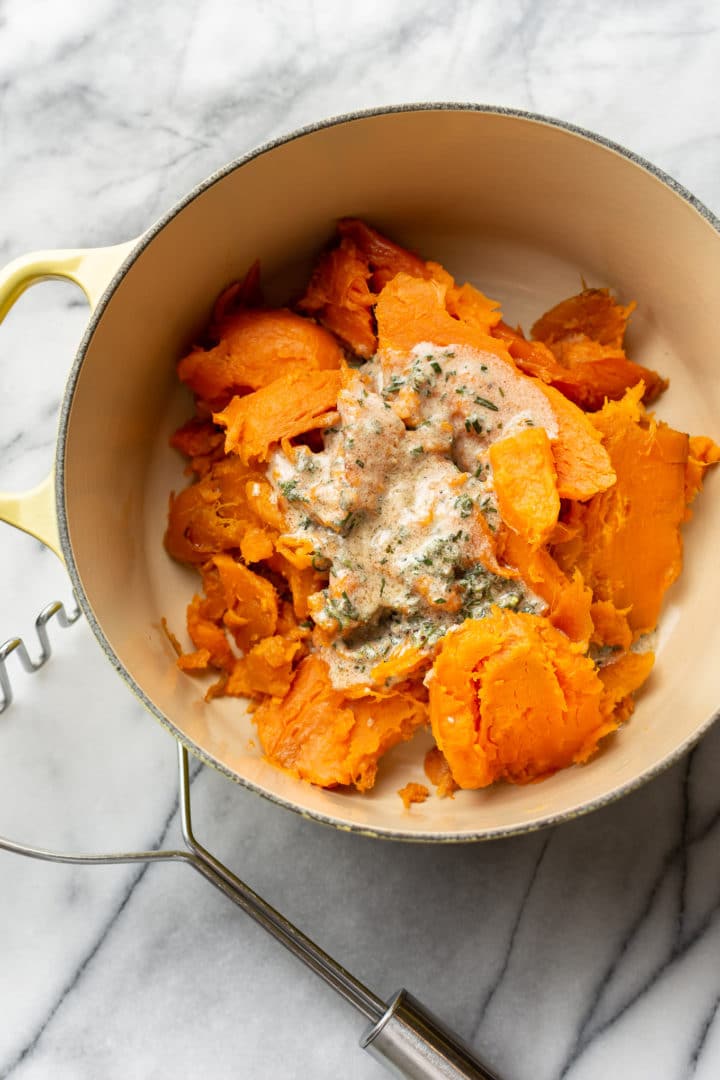 sweet potatoes ready to be mashed in a yellow pot