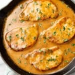 four pork chops with a ranch sauce in a cast iron skillet