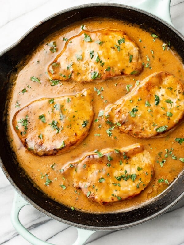 four pork chops with a ranch sauce in a cast iron skillet