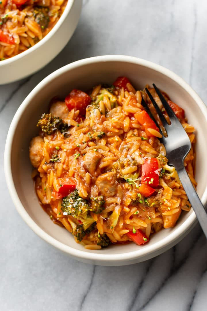 tomato orzo with chicken sausage and peppers in two bowls