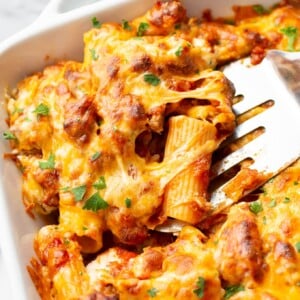 close-up of the best baked rigatoni in a casserole dish (portion is being lifted out with a spatula)