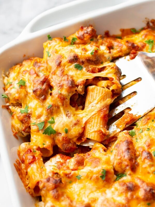 close-up of the best baked rigatoni in a casserole dish (portion is being lifted out with a spatula)