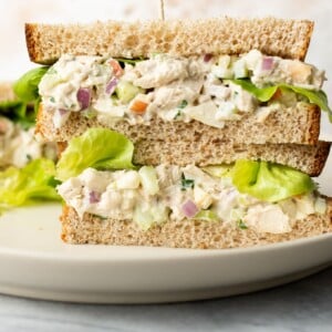 two classic chicken salad sandwiches stacked on top of each other